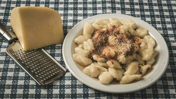 plato de hecho en casa Ñoquis con rallado queso en el mesa foto