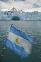 argentino bandera en perito moreno glaciar, los glaciares nacional parque, Papa Noel cruz provincia, Patagonia argentina. foto