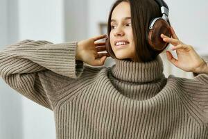 mujer auriculares contento bonito caucásico auriculares interior hogar joven música estudiante foto