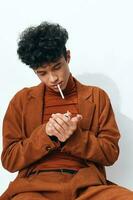 de moda hombre cigarrillo beige persona retrato estudiante Moda pensativo estilo de vida sentado de fumar en pie foto