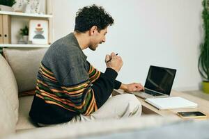 hombre negocio ordenador portátil hogar sofá emoción trabajando computadora sonrisa en línea tecnología Lanza libre foto