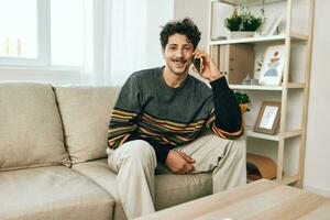 Confident man freelance smile phone sitting lifestyle couch internet cell talking success home photo