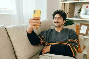 estilo de vida hombre comunicación mecanografía tecnología selfie cómodo teléfono sofá mensaje hogar foto
