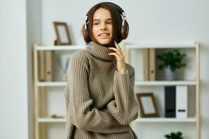 caucásico mujer interior estudiante joven auriculares contento auriculares hogar teléfono música foto