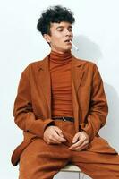 Cigarette man smoking fashion portrait sitting beige photo