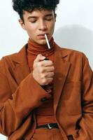 cigarrillo hombre pensativo Moda elegante sentado expresión sonriente estilo de vida estudiante uno retrato beige de fumar foto