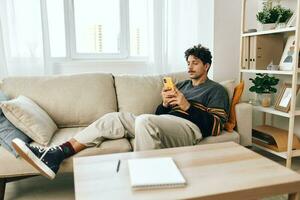 Freelance man communication typing lifestyle message sofa technology modern phone home photo