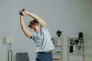 estilo de vida hombre pesas hogar formación rutina de ejercicio actividad deporte interior salud gris foto