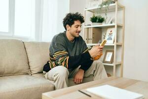 Man sofa phone adult message sitting communication home typing lifestyle freelance technology photo