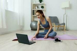 lifestyle woman exercise video health laptop training lotus mat yoga home photo