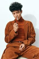 hombre negocio pensativo de fumar cigarrillo estilo de vida retrato sentado beige estudiante Moda foto