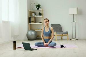 laptop woman training health lifestyle video water mat home yoga lotus photo