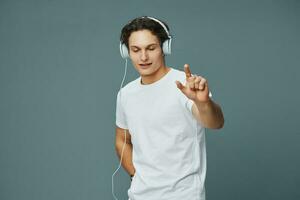 hombre auriculares joven contento danza retrato escucha música estilo de vida camiseta estudio foto