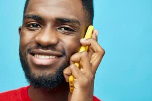 africano hombre mecanografía móvil joven sonrisa contento tecnología negro antecedentes estudio teléfono foto