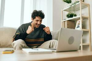 Freelance man online home using working laptop couch education smile computer business photo