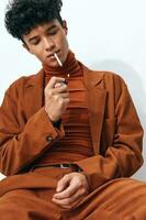 Man fashion student standing thoughtful portrait cigarette beige smoking smiling face lifestyle sitting photo