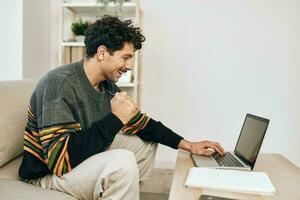 Man computer couch freelance laptop online guy business typing smile home working photo