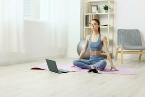 woman training lifestyle fitness laptop yoga lotus video mat home health photo