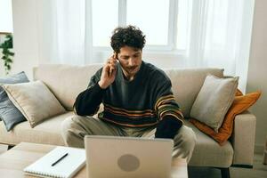 hombre Internet sofá caucásico alegre negocio sonrisa comunicación computadora en línea trabajando Lanza libre hogar ordenador portátil foto