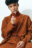 beige hombre confianza estilo de vida ropa moderno cigarrillo de fumar estudiante Moda sentado posando pensativo retrato foto