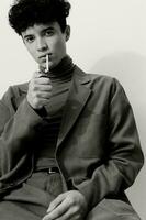 Cigarette man posing hipster looking sitting curly student thoughtful and white male black fashion portrait smoking photo