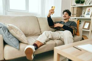 Man lifestyle typing person home sofa selfie communication young technology phone casual message photo