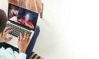 Man using his laptop to watch online tutorials photo