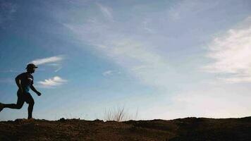 Slow motion. Men practice trail running in the evening. Silhouette of man running video