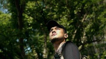 close up of the face of an Asian man enjoying the view of the mountains in the middle of a forest video