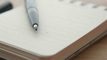 a pen and notepad on a wooden table video