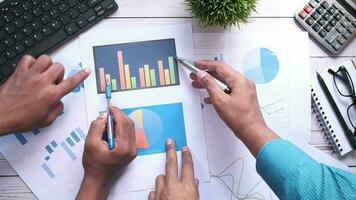 business people working on a table with graphs and papers video