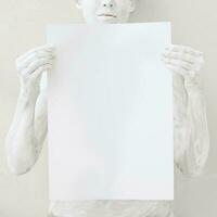 Blank design poster template. Woman covered with white paint holding  a paper. Focus on hands. photo