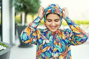 a woman wearing a colorful floral print hoodie photo