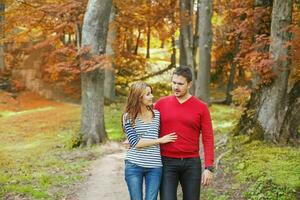 a man and woman walking on a path in the fall photo