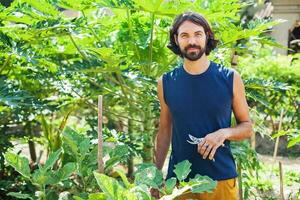 joven hombre jardinería y creciente vegetales foto