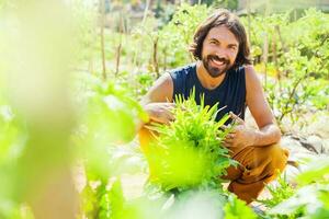 joven hombre jardinería y creciente vegetales foto