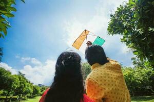 Back side faceless shot of two people flying Indian flag kite to celebrate national holiday Republic Day Independence day of India  Mahatma Gandhi birthday photo