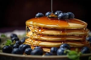 Delicious pancakes, with fresh blueberries and maple syrup flows from a stack of pancake photo