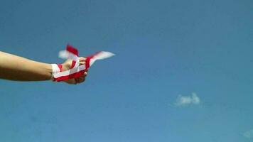 Hand with red and white ribbon with blue sky background, Indonesia independence day celebration concept video