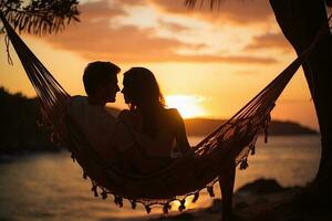 silueta de joven Pareja relajante en hamaca en tropical playa a puesta de sol ai generado foto