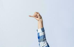 Hand gesturing the letter J in sign language on an isolated background. Man's hand gesturing the letter J of the alphabet isolated. Letters of the alphabet in sign language photo