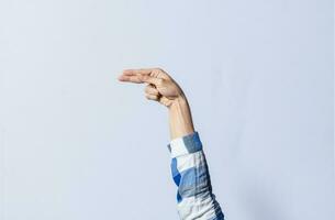 Hand gesturing the letter H in sign language on an isolated background. Man's hand gesturing the letter H of the alphabet isolated. Letters of the alphabet in sign language photo