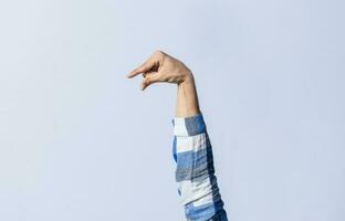 Hand gesturing the letter Q in sign language on an isolated background. Man's hand gesturing the letter Q of the alphabet isolated. Letter Q of the alphabet in sign language photo