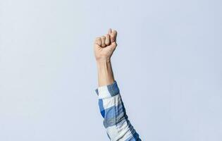 Hand gesturing the letter T in sign language on an isolated background. Man's hand gesturing the letter T of the alphabet isolated. Letter T of the alphabet in sign language photo