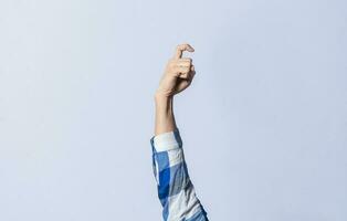 Hand gesturing the letter X in sign language on an isolated background. Man's hand gesturing the letter X of the alphabet isolated. Letter X of the alphabet in sign language photo