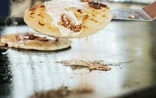 Traditional Nicaraguan Pupusas with melted cheese on grill. Traditional grilled cheese pupusas, Close up of traditional handmade pupusas on grill photo