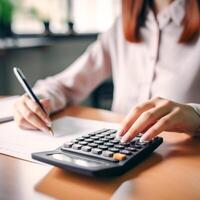 Modern Woman Working with Calculator in Office - Business Finance and Technology Concept, photo