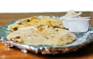 tradicional pupusas servido con ensalada en el mesa. dos nicaragüense pupusas con ensalada en el mesa, lado ver de delicioso salvadoreño pupusas con queso servido en el mesa. foto