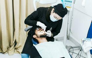 dentista ejecutando dental chequeo, dentista comprobación tirantes a paciente, paciente comprobado por dentista foto