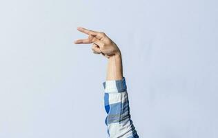 Hand gesturing the letter P in sign language on an isolated background. Man's hand gesturing the letter P of the alphabet isolated. Letter P of the alphabet in sign language photo